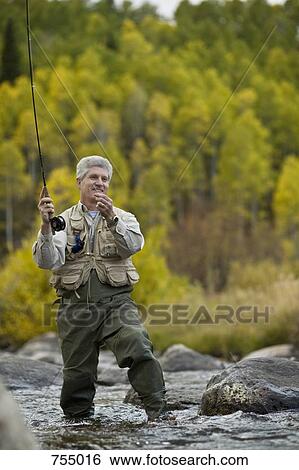 A man fly fishing in a river View Large Photo Image Stock Photograph - A man fly fishing in a river. Fotosearch