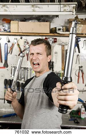 A man holding two socket wrenches and making a face View Large Photo Image Stock Image - A man holding two socket wrenches and making a face. Fotosearch