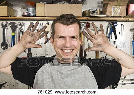 Stock Photo - A man holding up dirty hands. Fotosearch