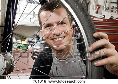 A man looking through a bicycle wheel View Large Photo Image Stock Photo - A man looking through a bicycle wheel. Fotosearch