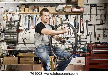 A man repairing a bicycle tire in a workshop View Large Photo Image Stock Photo - A man repairing a bicycle tire in a workshop. Fotosearch