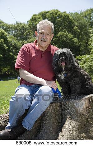 A man sitting with his dog in a park, Prospect Park, Brooklyn, New York, USA View Large Photo Image Stock Photo - A man sitting with his dog in a park, Prospect Park, Brooklyn, New York, USA. Fotosearch