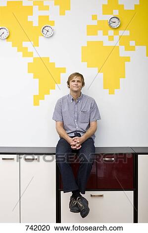 Stock Image - A man taking a break in an office. Fotosearch