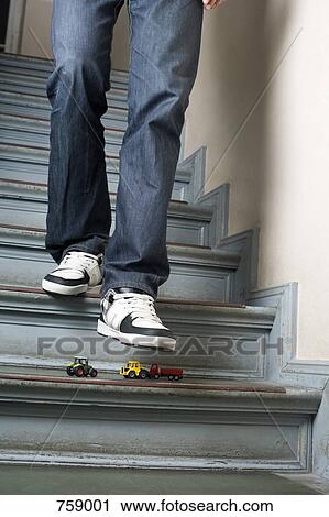 A man walking down stairs about to step on toy cars View Large Photo Image Stock Image - A man walking down stairs about to step on toy cars. Fotosearch