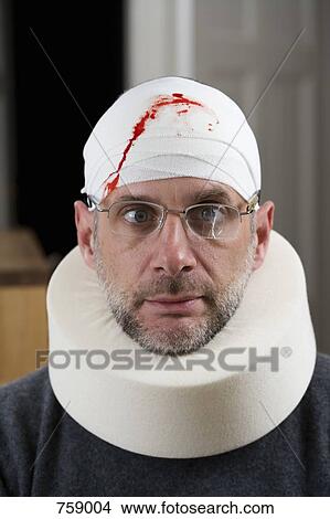 Picture - A man wearing cracked glasses, a bloody bandage on his head and a neck brace. Fotosearch