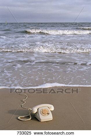 A rotary telephone on a beach at the water's edge View Large Photo Image Stock Photography - A rotary telephone on a beach at the water's edge. Fotosearch
