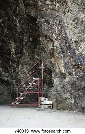 Stock Image - A step ladder next to a cave wall. Fotosearch