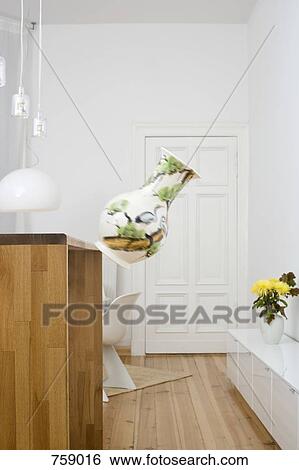 Stock Photograph - A vase falling from a counter. Fotosearch