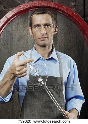 A vintner holds a glass wine thief View Large Photo Image Stock Image - A vintner holds a glass wine thief. Fotosearch