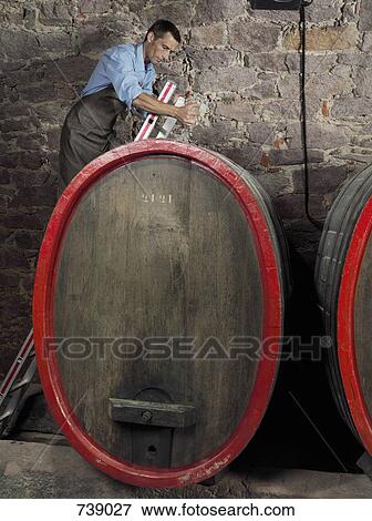 A vintner using a glass wine thief to get a sample from a barrel View Large Photo Image Stock Photo - A vintner using a glass wine thief to get a sample from a barrel. Fotosearch