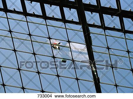 A window cleaner standing on a glass roof View Large Photo Image Picture - A window cleaner standing on a glass roof. Fotosearch