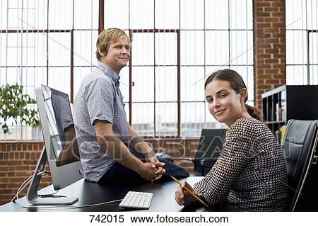 Stock Photography - A woman and a man in an office. Fotosearch