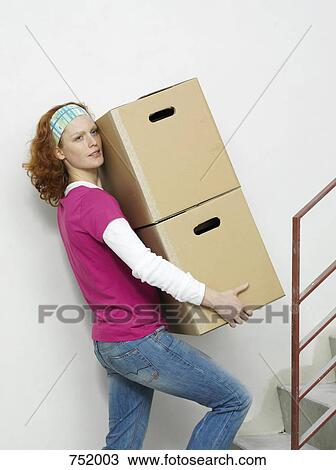 A woman carrying boxes up stairs View Large Photo Image Stock Image - A woman carrying boxes up stairs. Fotosearch