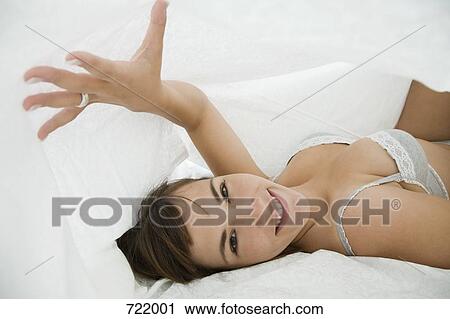 A woman lying under bed covers View Large Photo Image Stock Image - A woman lying under bed covers. Fotosearch