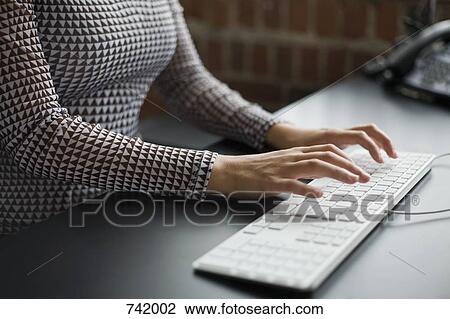A woman typing on a keyboard View Large Photo Image Stock Image - A woman typing on a keyboard. Fotosearch