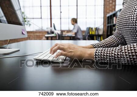 A woman using a computer in an office View Large Photo Image Stock Photo - A woman using a computer in an office. Fotosearch