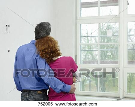 A young couple standing in their new home View Large Photo Image Stock Photography - A young couple standing in their new home. Fotosearch