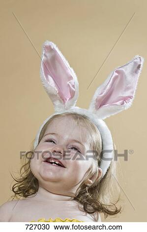 A young girl wearing a rabbit-ear hair band View Large Photo Image Stock Image - A young girl wearing a rabbit-ear hair band. Fotosearch