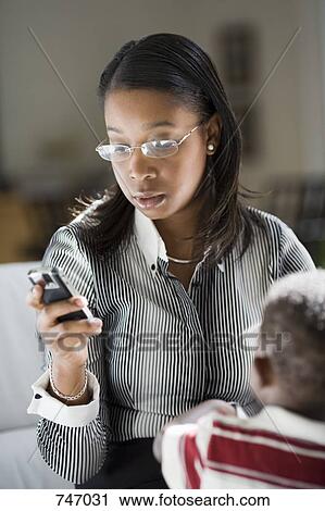 A young woman using a mobile phone View Large Photo Image Stock Image - A young woman using a mobile phone. Fotosearch