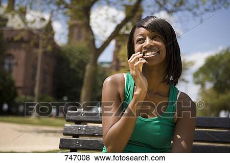 A young woman using a mobile phone View Large Photo Image Stock Photo - A young woman using a mobile phone. Fotosearch