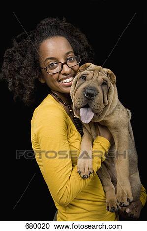 Stock Image - A young woman with her Shar-Pei, studio shot. Fotosearch