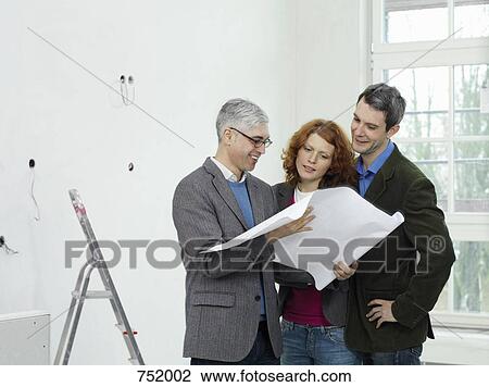 An architect going over blueprints with a young couple View Large Photo Image Stock Image - An architect going over blueprints with a young couple. Fotosearch