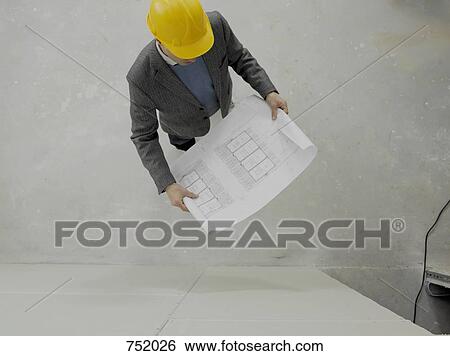 Stock Photograph - An architect reviewing work on a construction site. Fotosearch