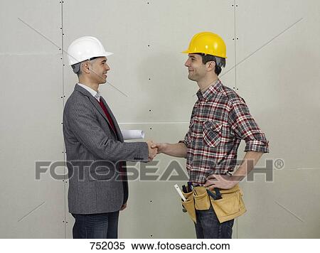 An architect shaking hands with a construction worker View Large Photo Image Stock Photography - An architect shaking hands with a construction worker. Fotosearch