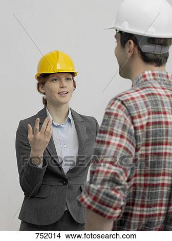 An architect speaking with a construction worker View Large Photo Image Picture - An architect speaking with a construction worker. Fotosearch