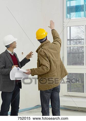 Stock Photography - An architect speaking with a construction worker. Fotosearch