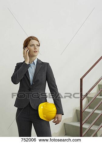 An architect talking on a mobile phone on a building site View Large Photo Image Stock Photograph - An architect talking on a mobile phone on a building site. Fotosearch