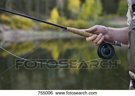 Stock Photograph - Detail of a man holding a fly rod. Fotosearch