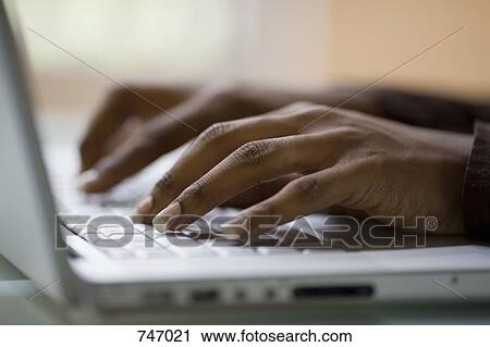 Stock Image - Detail of a woman typing on a laptop. Fotosearch