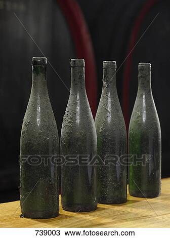 Four dusty wine bottles in a winery View Large Photo Image Stock Image - Four dusty wine bottles in a winery. Fotosearch