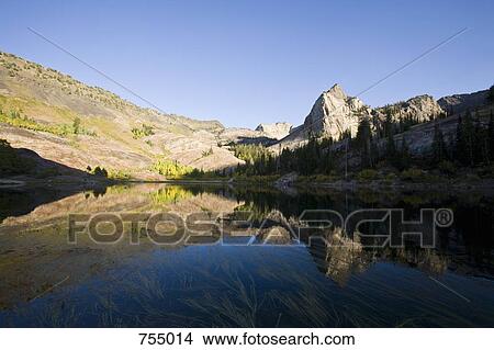 Lake surrounded by rocky mountains View Large Photo Image Picture - Lake surrounded by rocky mountains. Fotosearch