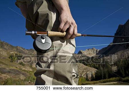 Midsection of a man holding a fly rod View Large Photo Image Stock Image - Midsection of a man holding a fly rod. Fotosearch