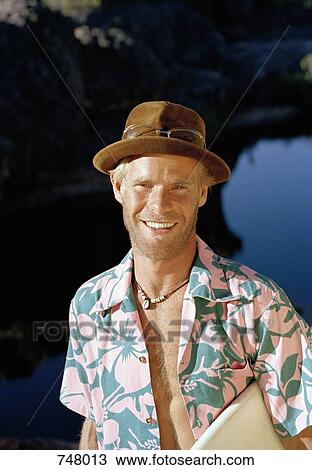 Portrait of a man holding a surfboard View Large Photo Image Stock Image - Portrait of a man holding a surfboard. Fotosearch