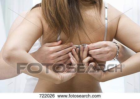 Rear view of a man unfastening a woman's bra View Large Photo Image Stock Photograph - Rear view of a man unfastening a woman's bra. Fotosearch