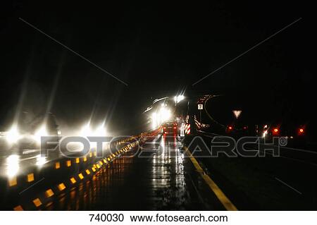 Traffic driving along a highway at night View Large Photo Image Stock Image - Traffic driving along a highway at night. Fotosearch