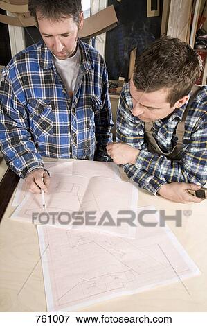 Two carpenters discussing plans View Large Photo Image Stock Photo - Two carpenters discussing plans. Fotosearch