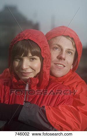 Young couple wearing raincoats View Large Photo Image Stock Image - Young couple wearing raincoats. Fotosearch