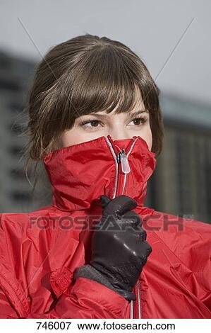 Young woman with collar of rain jacket covering mouth View Large Photo Image Stock Photo - Young woman with collar of rain jacket covering mouth. Fotosearch