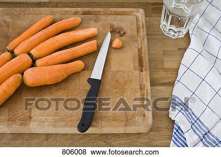 A cutting board with knife and carrots, still life View Large Photo Image Stock Photo - A cutting board with knife and carrots, still life. Fotosearch