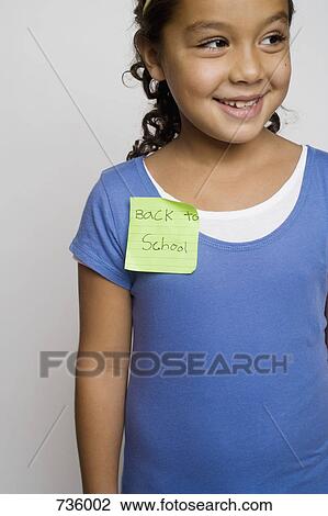 Stock Image - A girl wearing a Back To School sticker. Fotosearch