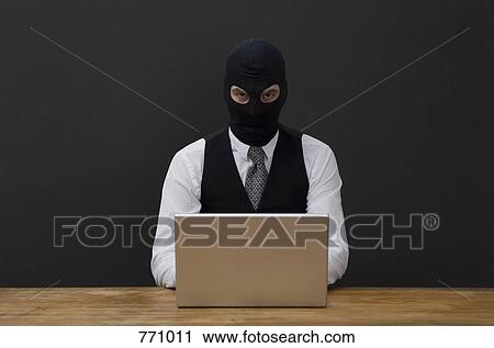 A man wearing a balaclava and using a laptop View Large Photo Image Stock Image - A man wearing a balaclava and using a laptop. Fotosearch