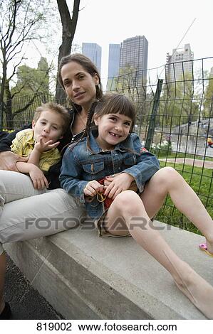 A woman and her children sitting together on a park bench, Central Park, New York City View Large Photo Image Stock Image - A woman and her children sitting together on a park bench, Central Park, New York City. Fotosearch