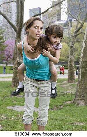 Picture - A woman carrying her daughter on her back, Central Park, New York City. Fotosearch