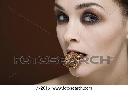 A woman with an almond chocolate cluster in her mouth View Large Photo Image Stock Photography - A woman with an almond chocolate cluster in her mouth. Fotosearch