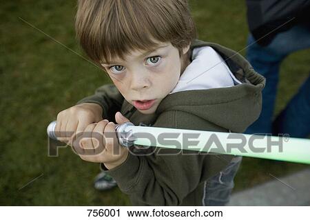 A young boy holding a toy sword View Large Photo Image Stock Image - A young boy holding a toy sword. Fotosearch