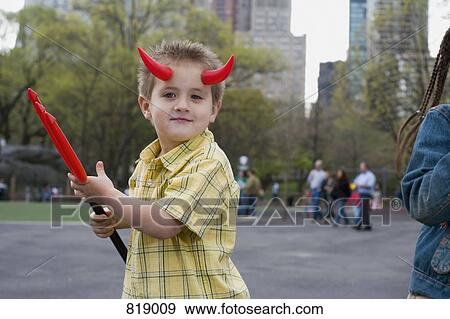 A young boy wearing devils horns and holding a pitchfork, Central Park, New York City View Large Photo Image Stock Photo - A young boy wearing devils horns and holding a pitchfork, Central Park, New York City. Fotosearch